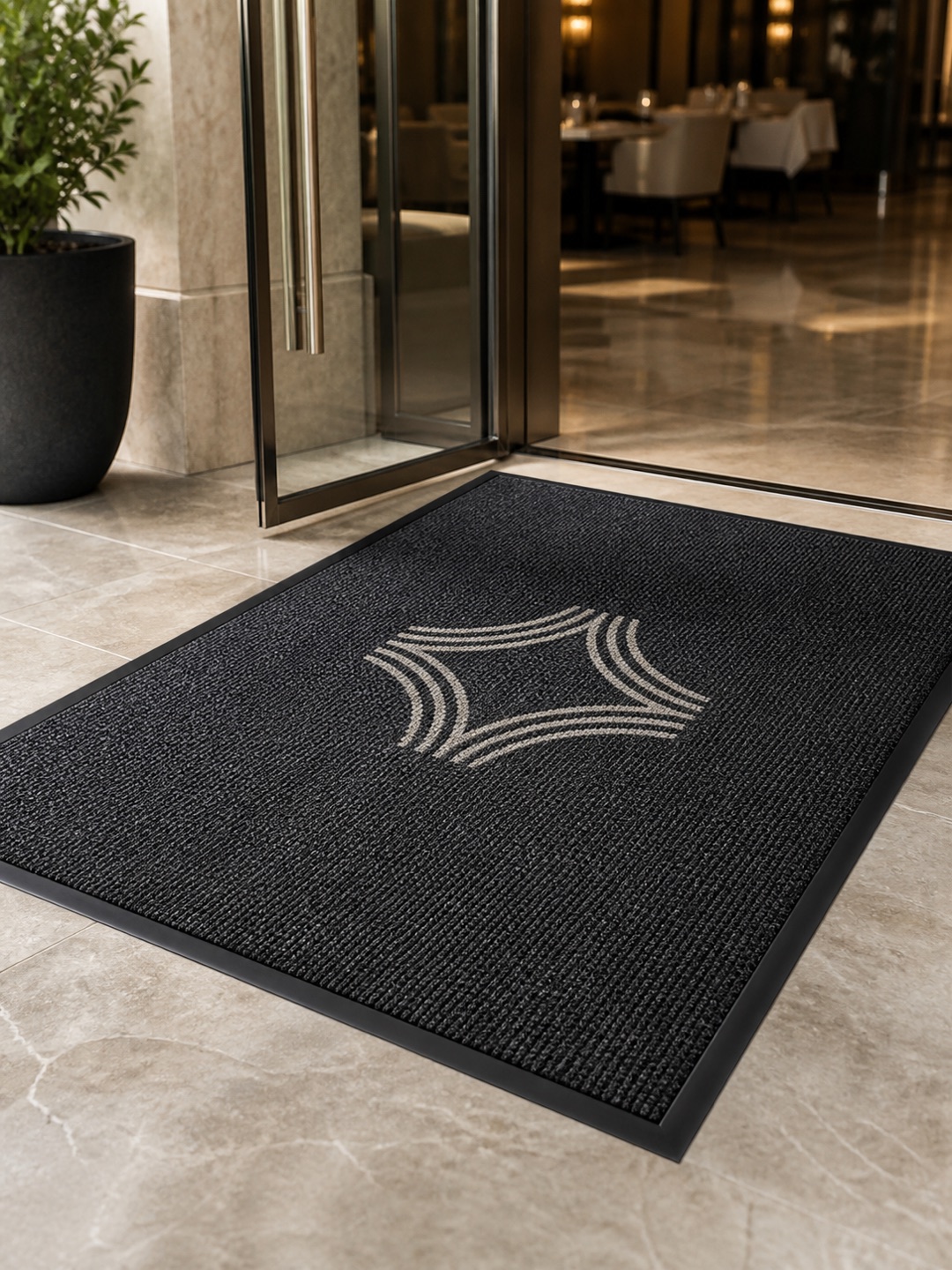 Charcoal entrance mat with a woven geometric design at a restaurant entrance