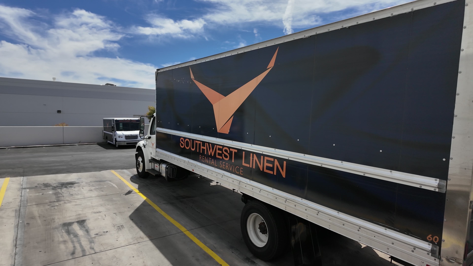 Southwest Linen branded delivery trucks at the loading area